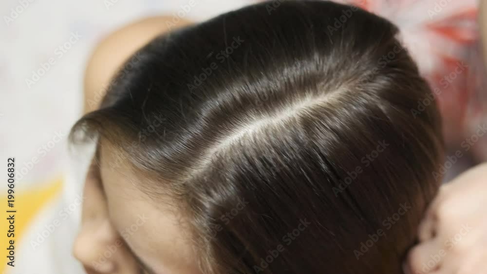 Mother treating her daughter's hair against lice Mother treating her daughter's hair against lice
