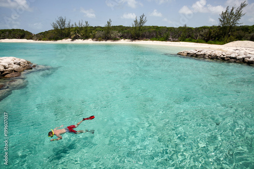 Man snorkelling in transparent water beach.