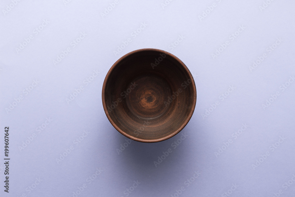 Empty brown plate on pastel purple background, top view, flat lay Empty brown plate on pastel purple background, top view, flat lay