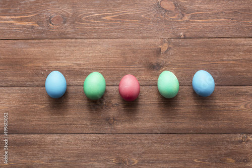 Happy easter eggs on color for holiday on wooden background top view flat lay
