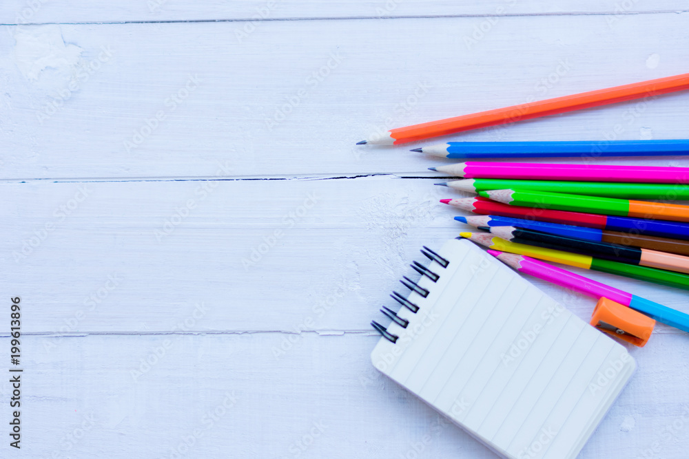School items on a wooden table, Pencils and student pens on a wooden surface School items on a wooden table, Pencils and student pens on a wooden surface