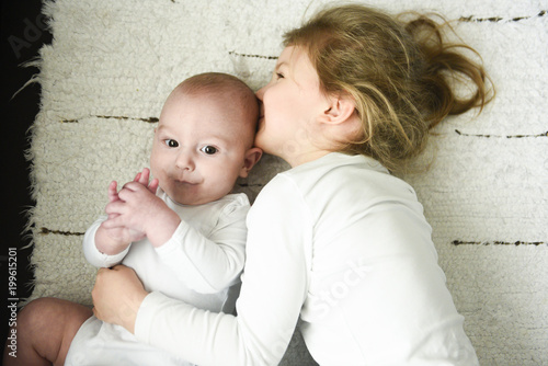 sister girl hugs newborn brother