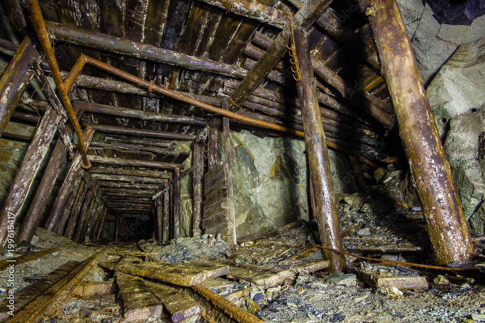 Underground abandoned gold ore mine shaft tunnel gallery with wooden timber Underground abandoned gold ore mine shaft tunnel gallery with wooden timber