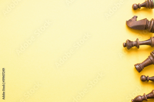Chess game figures on yellow background , top view, flat lay copy space