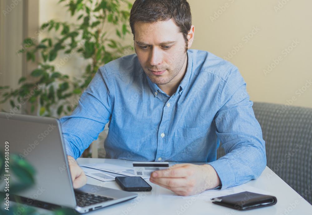 Handsome man paying by credit card in internet shop. Handsome man paying by credit card in internet shop.