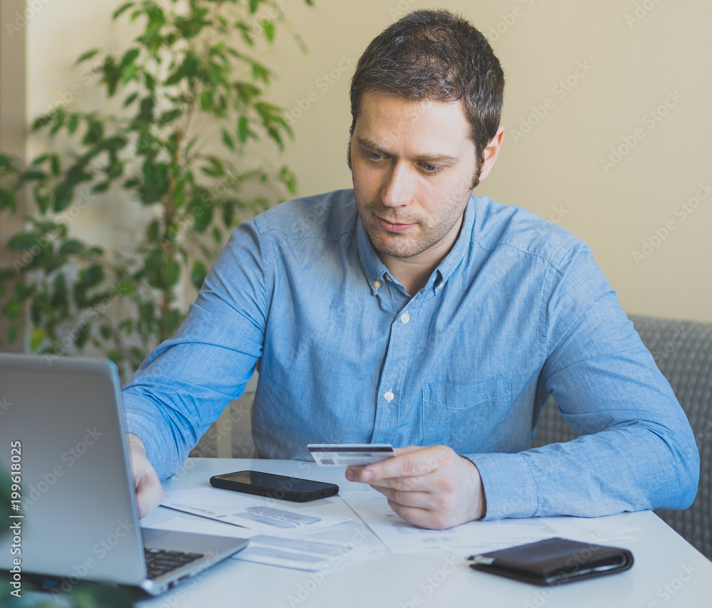 Handsome man paying by credit card in internet shop. Handsome man paying by credit card in internet shop.