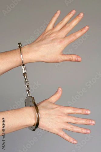 Close-up view . Arrested woman handcuffed hands. Prisoner or arrested terrorist, close-up of hands in handcuffs. Criminal female hands locked in handcuffs.