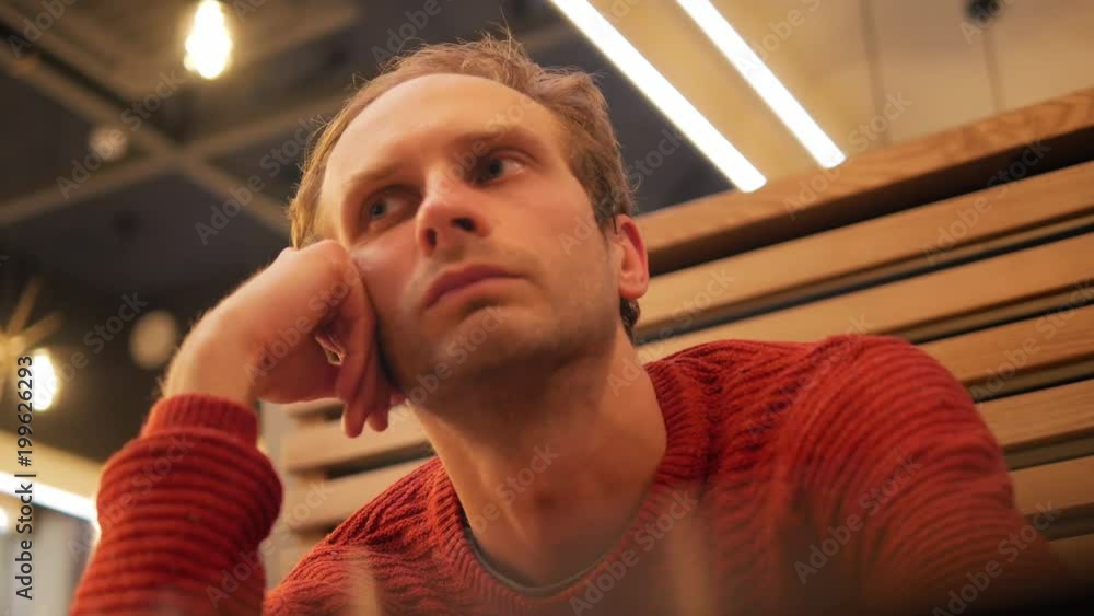4k Man with blond hair and red pullover siting in cafe, dreaming and waiting for his girlfriend 4k Man with blond hair and red pullover siting in cafe, dreaming and waiting for his girlfriend