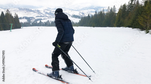 A young man in sports glasses and skiing in the mountains