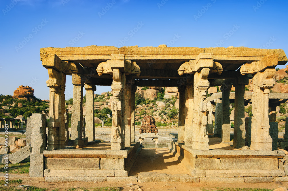 Fototapeta premium Market complex near temple tank Pushkarani on the way to the Vitthala temple, Hampi, Karnataka, India. Ancient ruins of Vijayanagara Empire. UNESCO World Heritage Site