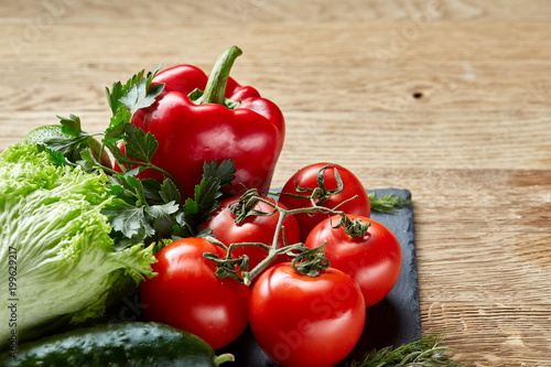 Healthy breakfast with tomatoes, letucce, lime on wooden background, close-up, selective focus, top view.