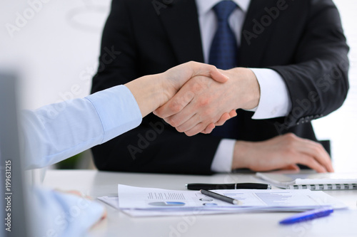 Close Up of unknown business people shaking hands while finishing up a meeting. Handshaking, agreement or success concept in people communication © rogerphoto