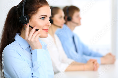 Call center operators. Focus at business woman in headset