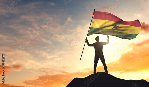 Ghana flag being waved by a man celebrating success at the top of a mountain. 3D Rendering
