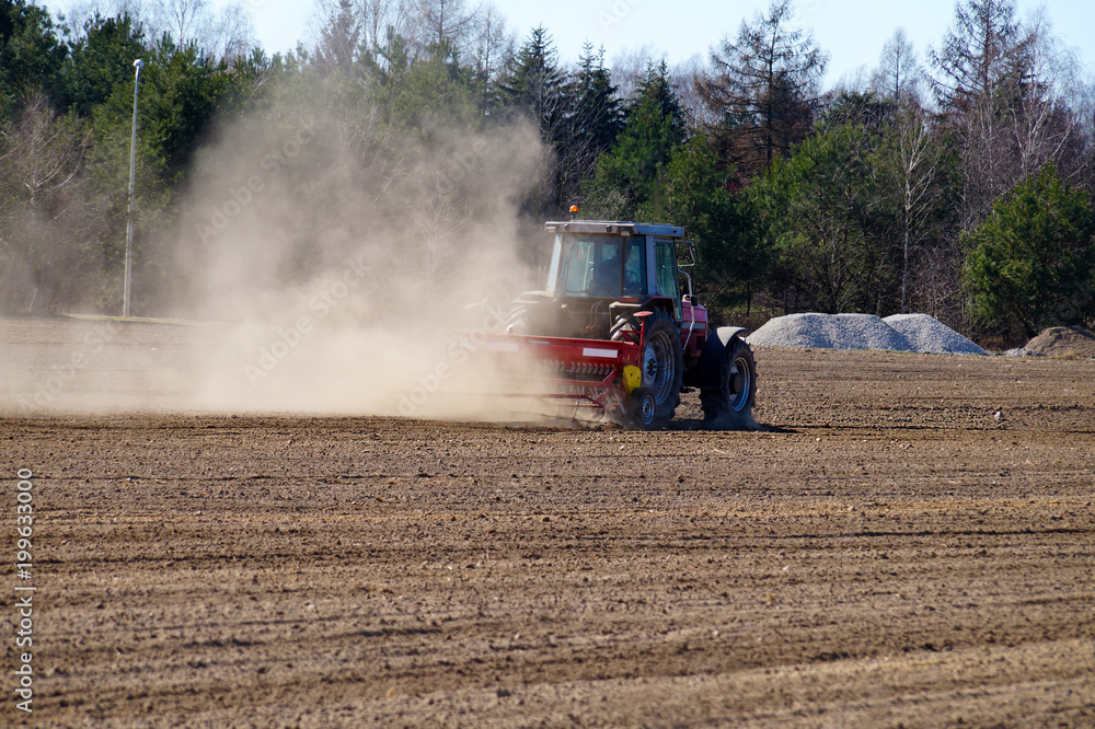 Fototapeta premium Spring field work. The act of harrowing the field for cultivation
