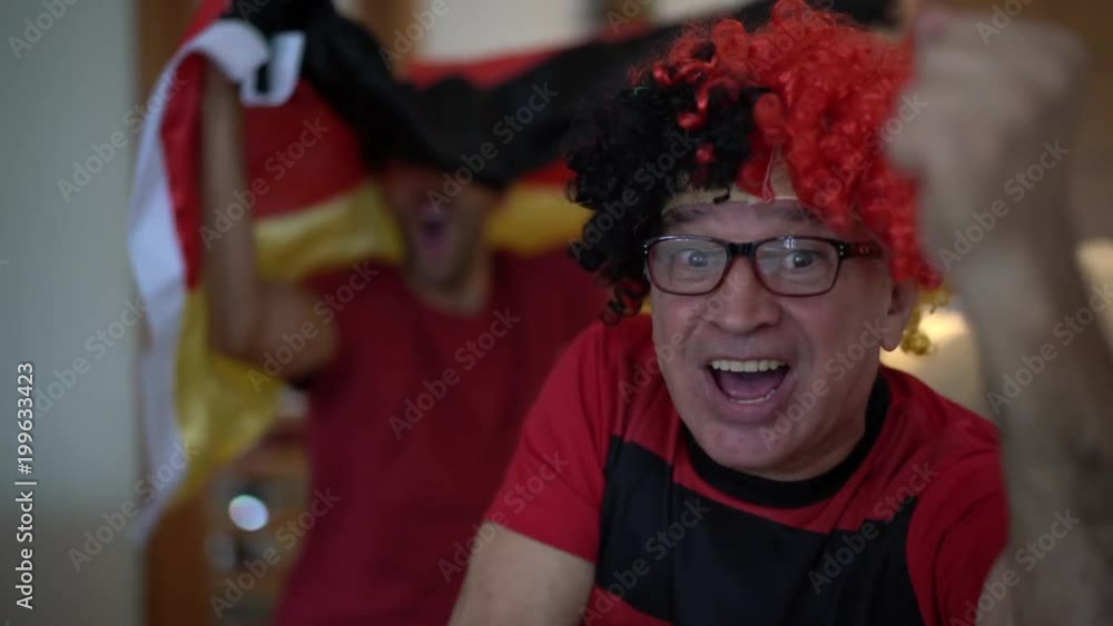 German Father and Son Fans Watching and Celebrating a Soccer Game German Father and Son Fans Watching and Celebrating a Soccer Game