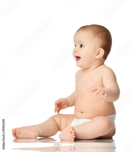 Infant child baby boy toddler sitting in diaper playing isolated on white 