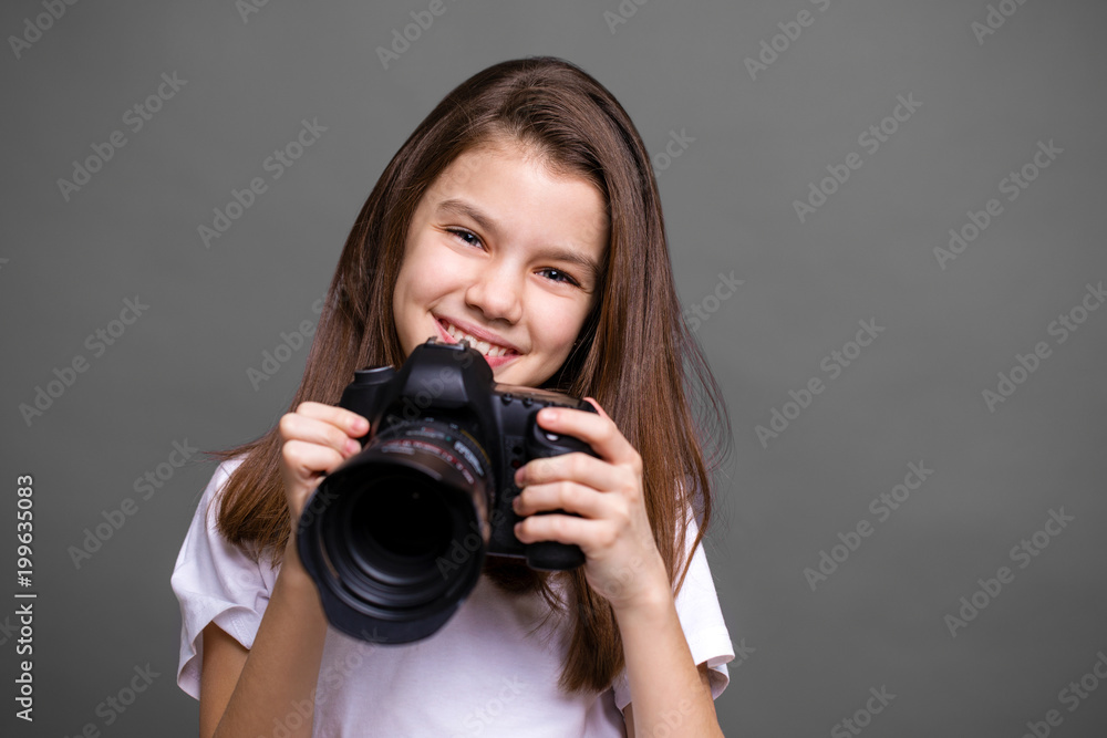 Cute brunette little girl holding an photo camera Cute brunette little girl holding an photo camera