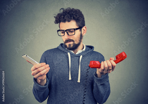 Confused man with old and new phones
