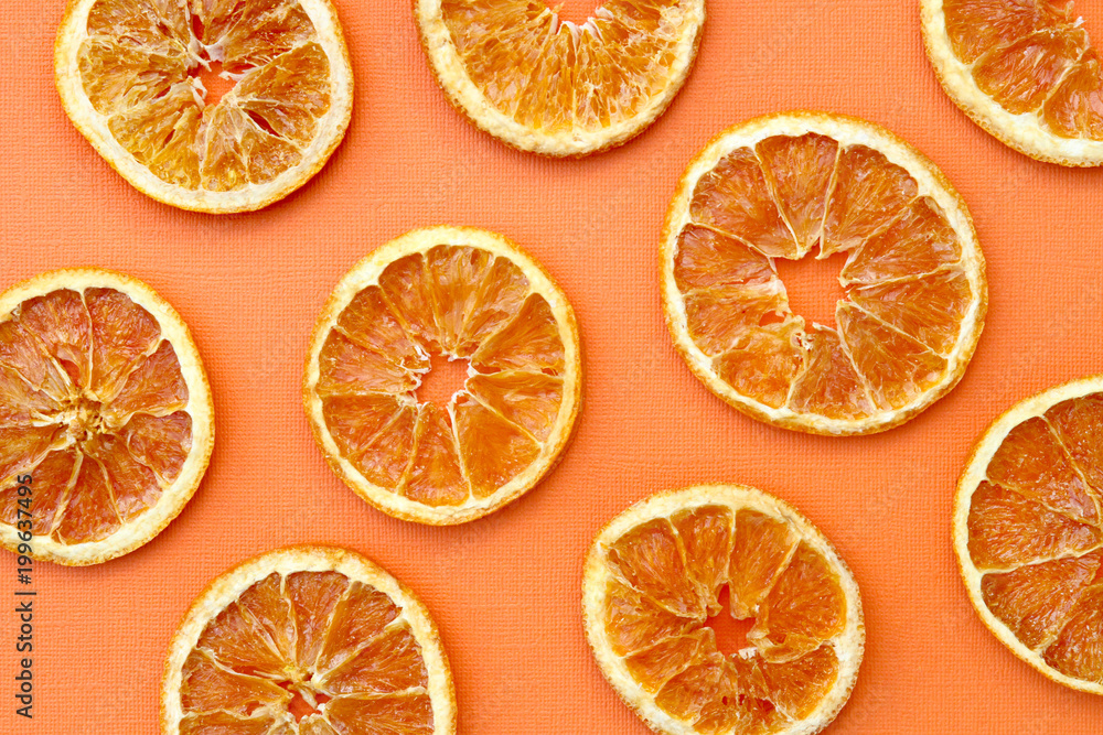 Dried Sliced Oranges in Graphic Pattern on Orange Background Dried Sliced Oranges in Graphic Pattern on Orange Background