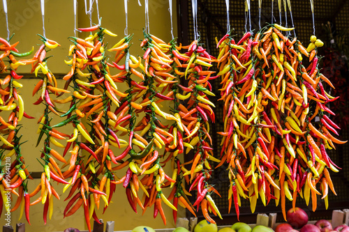 Strands of Colorful Peppers in a Market © dbvirago