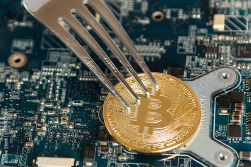 Bitcoin Digital Cryptocurrency Hard Fork Change Concept. Virtual Crypto Currency Coin On Computer Mohterboard. photo