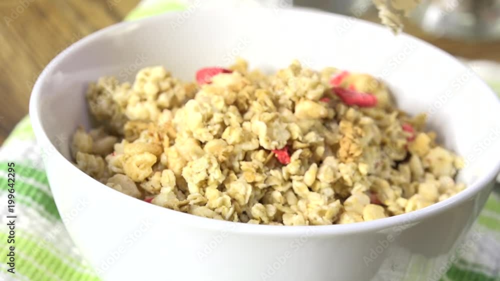 Pouring granola into a bowl slow motion