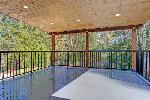 Covered deck with wooden ceiling and iron handrails. © Javani LLC
