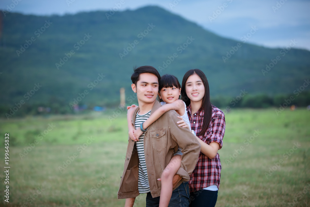 happy asian family and the child sits on the shoulders of his father and children daughters having fun and playing in nature.