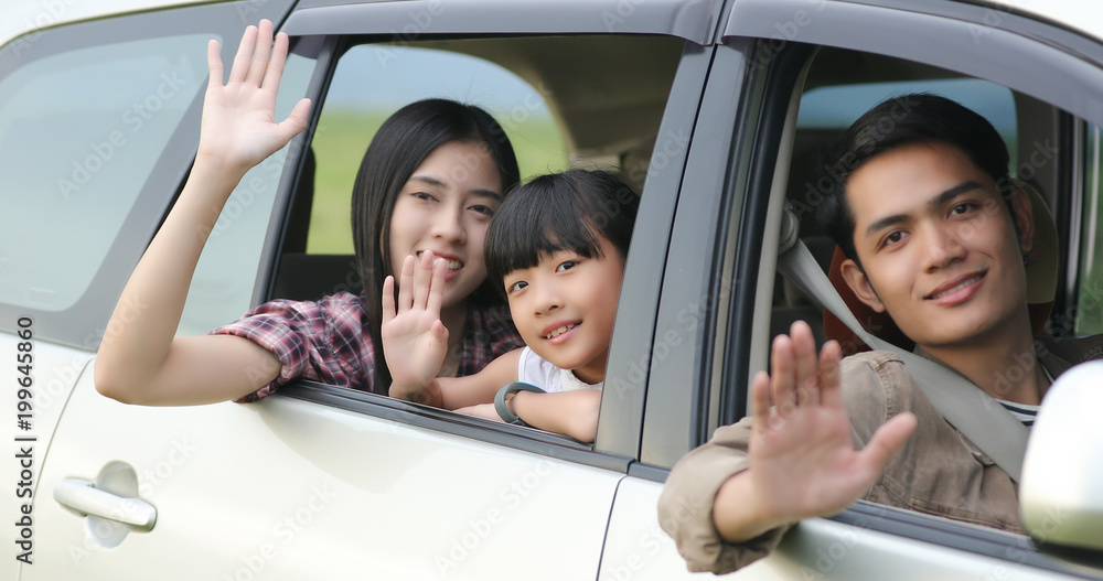 Happy little girl  with asian family sitting in the car for enjoying road trip and summer vacation in camper van