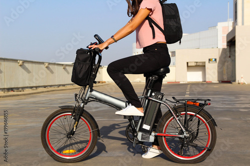 A young woman with an electric bicycle