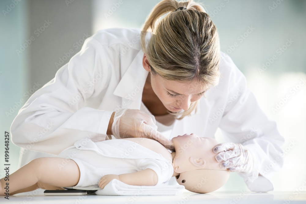 Doctor practising infant CPR Doctor practising infant CPR