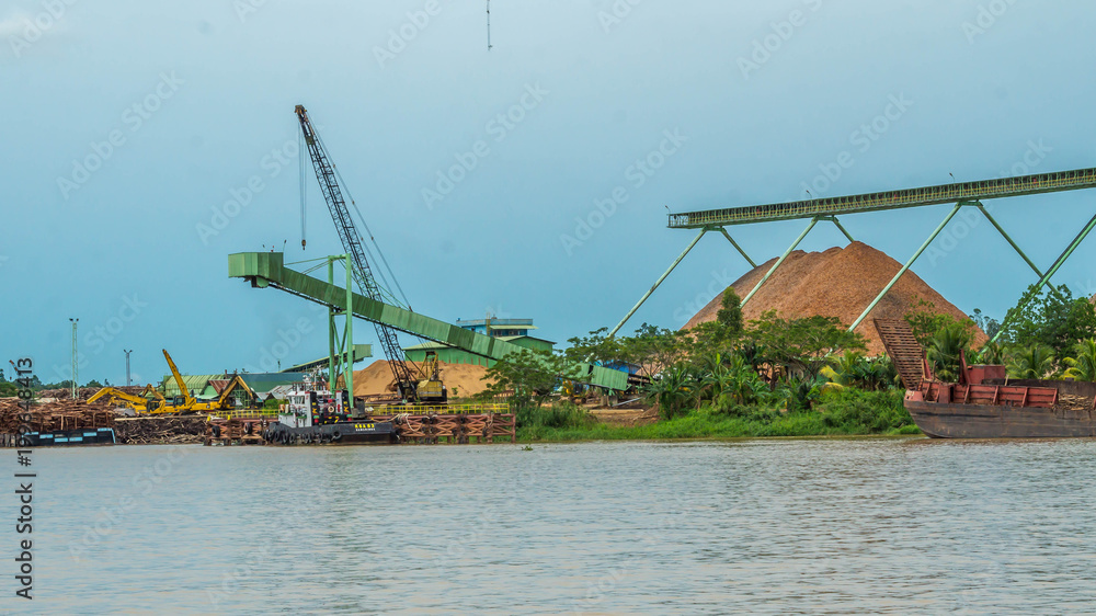 wood chip stockpile factory on Mahakam riverbank. industrial background wood chip stockpile factory on Mahakam riverbank. industrial background