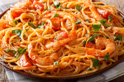 Spicy spaghetti with shrimps in tomato sauce close-up. horizontal