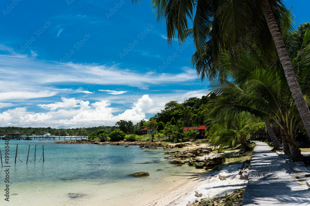 Tropical landscape of Koh Rong Samloem island with turquoise water, palm tree and mountain in the distance. Cambodia, asia. Tropical landscape of Koh Rong Samloem island with turquoise water, palm tree and mountain in the distance. Cambodia, asia.