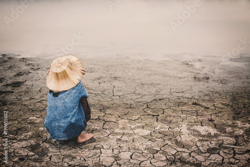 Φωτογραφία Sad girl and exhausted on cracked dry ground, Concept drought and shortage of wa