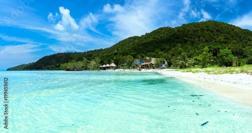 Tropical landscape of Koh Rong Samloem island with turquoise water, palm tree and mountain in the distance. Cambodia, asia. photo