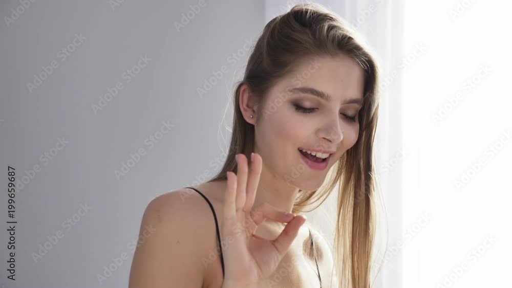 Young beautiful sexy girl in black lingerie showing ok sign, flirts, tempts, smiling, sunlight, near the window, curtain 50 fps Young beautiful sexy girl in black lingerie showing ok sign, flirts, tempts, smiling, sunlight, near the window, curtain 50 fps