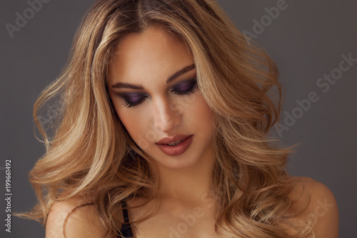 Gorgeous blonde woman closeup portrait wearing purple eyeshadow