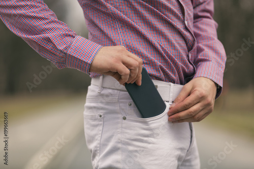 Modern businessman using smart phone outdoors.