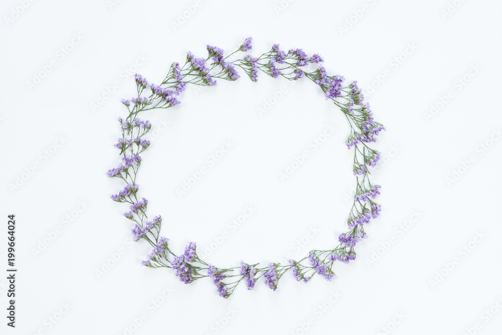 Top view of round flower frame with violet flowers and copy space isolated on white background, flat lay. Greeting card concept