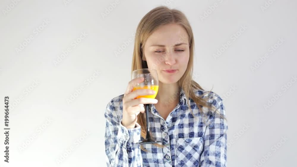 Girl drinks fresh orange juice and looks into the camera Girl drinks fresh orange juice and looks into the camera