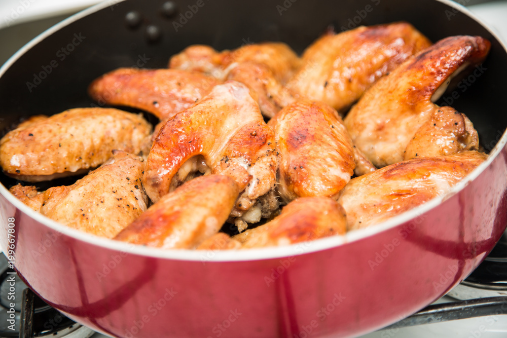 Closeup of baked chicken wings in baking pan. Selective focus Closeup of baked chicken wings in baking pan. Selective focus