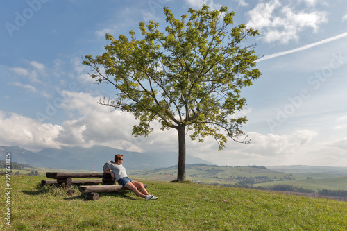 Woman sitting on summer hill near Liptovsky Trnovec, Slovakia.