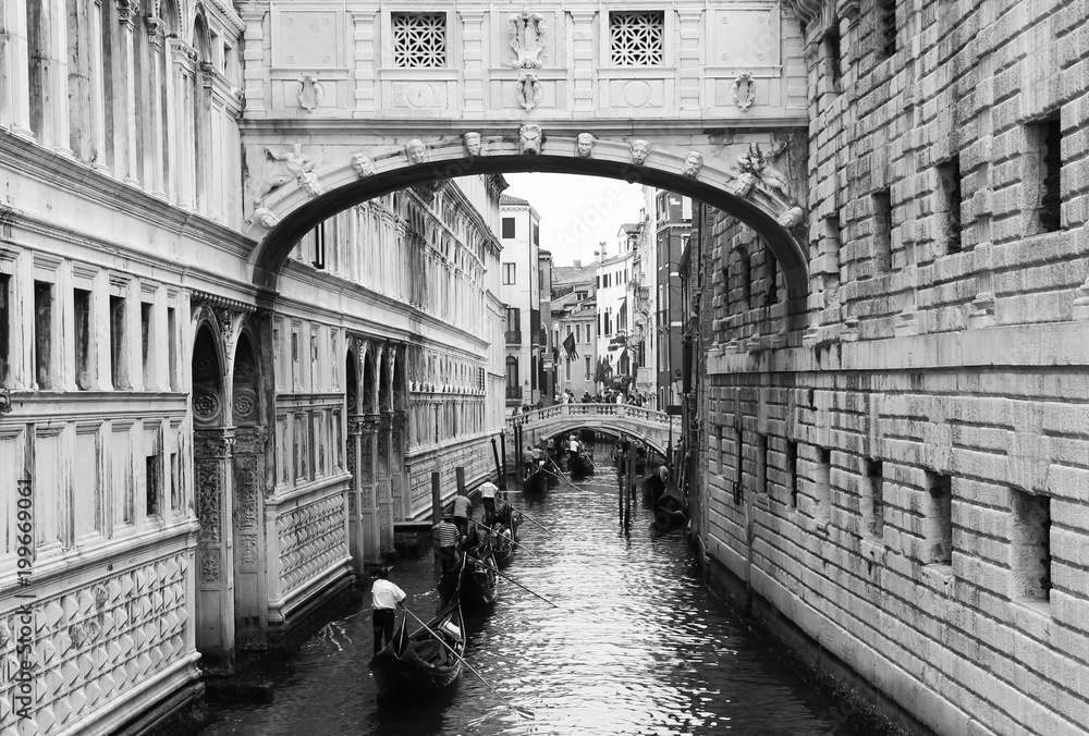 A queue of Gondaliers and their customers travelling through the ancient canals of Venice.