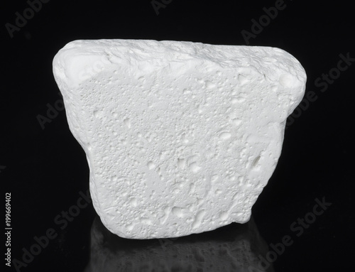 Specimen of Mineral kaolinite (kaolin) on black background. The main use of kaolinite is the production of paper .  photo