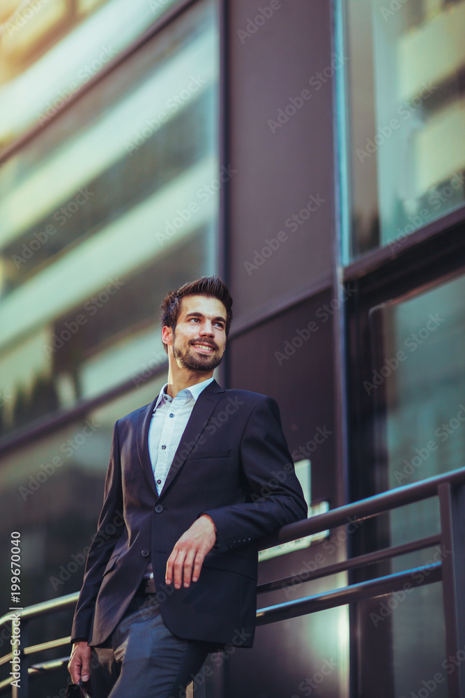 Portrait of a young happy businessman outside the office building Portrait of a young happy businessman outside the office building