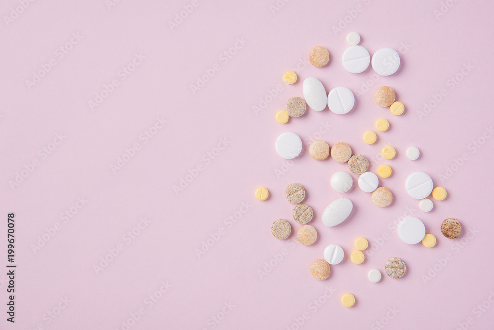 Different tablets and pills in the package and without it on a pink background Different tablets and pills in the package and without it on a pink background