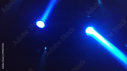 Two blue projectors on the ceiling of the techno club rotate photo