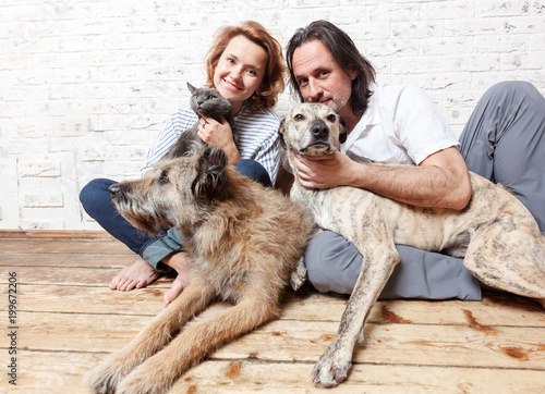 Sticker Attractive man and his young wife with pets, two dogs and a cat, a family portra